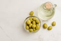 Olive oil bottle and olives on white stone table. Top view and copy space. Olive oil in a bottle and fruits of olives in a bowl Royalty Free Stock Photo