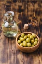 Olive oil bottle and olives on wooden background. Top view. Olive oil in a bottle and fruits of olives in a wooden bowl Royalty Free Stock Photo