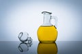 Olive oil bottle, vegetable salad flavoring. Gray background. Yellow cooking oil in a glass jar Royalty Free Stock Photo