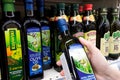 Olive oil bottles in supermarket. Bottle of olive oil in the hand of the buyer at the shop. Royalty Free Stock Photo