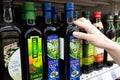 Olive oil bottles in supermarket. Bottle of olive oil in the hand of the buyer at the shop. Royalty Free Stock Photo