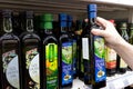 Olive oil bottles in supermarket. Bottle of olive oil in the hand of the buyer at the shop. Royalty Free Stock Photo