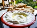 Olive oil in a bowl of labneh, a delicious traditional Arab yoghurt cream cheese dip, with freshly-baked flat bread in the