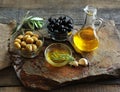 Olive oil in a bowl and carafe on vintage wooden boards.