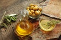 Olive oil in a bowl and carafe on vintage wooden boards.