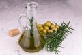 Olive oil decanter and rosemary branches on a white background.