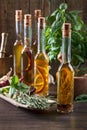 Olive oil with different spices and herbs on a wooden table. Royalty Free Stock Photo