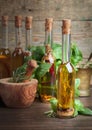 Olive oil with different spices and herbs on a wooden table. Royalty Free Stock Photo