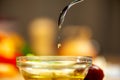 Olive oil flows from a teaspoon of tituand and droplets