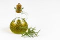 Olive oil in glass bottle, rosemary branches isolated on white background. Free space for text