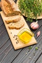 Olive oil in glass bowl. Pieces of bread on cutting board Royalty Free Stock Photo