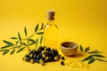 Olive oil and olives. Bottle of oil. olives twigs and pepper on yellow.