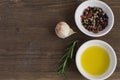 Olive oil porcelain plate Rosemary branch Pepper mix Garlic Seasoning Spices Cooking concept Wooden background