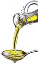 Olive oil poured from a bottle on a metal spoon. Royalty Free Stock Photo