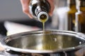 Olive oil is poured from a bottle into a saucepan Royalty Free Stock Photo