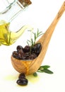 Olive oil poured into a wooden spoon full of olives Royalty Free Stock Photo