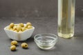 Olive oil pouring from bottle in bowl and fresh olives in ceramic plate Royalty Free Stock Photo