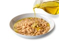 olive oil pouring from glass jug over bean soup Royalty Free Stock Photo