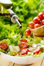 Olive oil pouring over salad Royalty Free Stock Photo