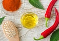 Olive oil, wooden hairbrush, fresh red chili peppers and dry chili powder for preparing diy hair mask for hair loss therapy. Royalty Free Stock Photo