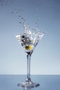 Olive splashing in a Martini glass
