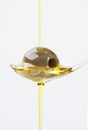 Olive on spoon with olive oil pouring over Royalty Free Stock Photo