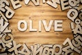 OLIVE word made with block letters lying on wooden board