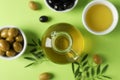 Olives, bottle and bowl with olive oil on background, top view and close up Royalty Free Stock Photo