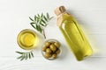 Olives, bottle and bowl with olive oil on background, top view Royalty Free Stock Photo