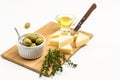 Olives in ceramic bowl. Parmesan cheese, knife and thyme sprigs on cutting board Royalty Free Stock Photo