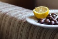 Olives and lemon on a plate.