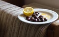 Olives and lemon on a plate.