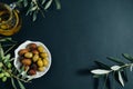 Olives, oil and green branch on black background, Top view, space for rext Royalty Free Stock Photo