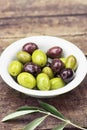 Olives and olive branches on a wooden rustic background. Rustic still life