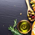 Olives, olive oil rosemary and bread on black slate background. Top view copy space Royalty Free Stock Photo