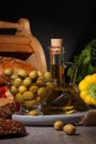 Olives, olive oil, vegetables and bread on a dark background Royalty Free Stock Photo