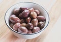 Olives in a small bowl on wooden table