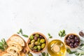 Olives, ciabatta and olive oil on white background.