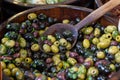 Olives in wooden bowls with serving spoon.