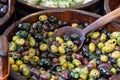 Olives in wooden bowls with serving spoon.