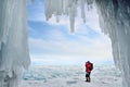 Olkhon island, Baikal, Russia, 12, March, 2017.Tourist photographing ice hummocks on lake Baikal in the background of the ice grot