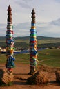 Olkhon / Russia - 27 June 2019: Shaman rock at lake Baikal with the sunset light. The bars of the hitching post tied with ribbons Royalty Free Stock Photo