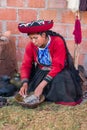 Ollantaytambo, Peru - circa June 2015: Woman in traditional Peruvian clothes uses natural dye for Alpaca and Llama wool near Cusco Royalty Free Stock Photo