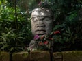 Olmec sculpture carved from stone. Mayan symbol - Big stone head statue in a jungle