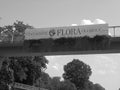 Grey shaded - Main Gateway of Flora Exposition with sign and multiple flowers hanging on a bridge