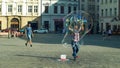 OLOMOUC, CZECH REPUBLIC, JUNE 11, 2019: Making bubbles using detergent soap and rope on chopsticks, big bubble, street