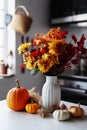 olorful autumn composition, bouquet of leaves and pumpkin in a vase on kitchen table. Royalty Free Stock Photo
