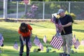 olunteers placing an American Flag on the grave of a Military Veteran for Memorial Day