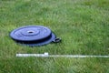 Olympic barbell with black weight plates on a green lawn, ready for an outdoor workout