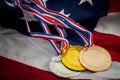 Olympic glory and triumph in sports competition concept with three medals gold, silver and bronze on the USA flag, representing